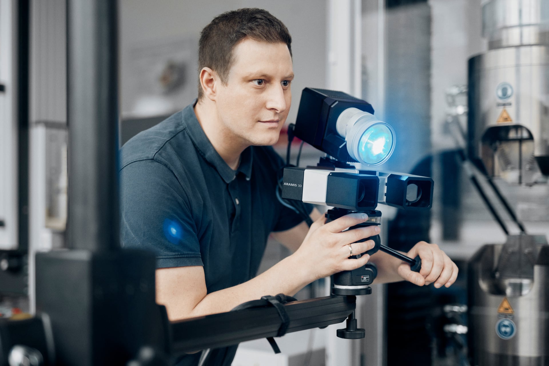 Positioning an industrial ARAMIS stereo camera and blue-light projector beside a test machine