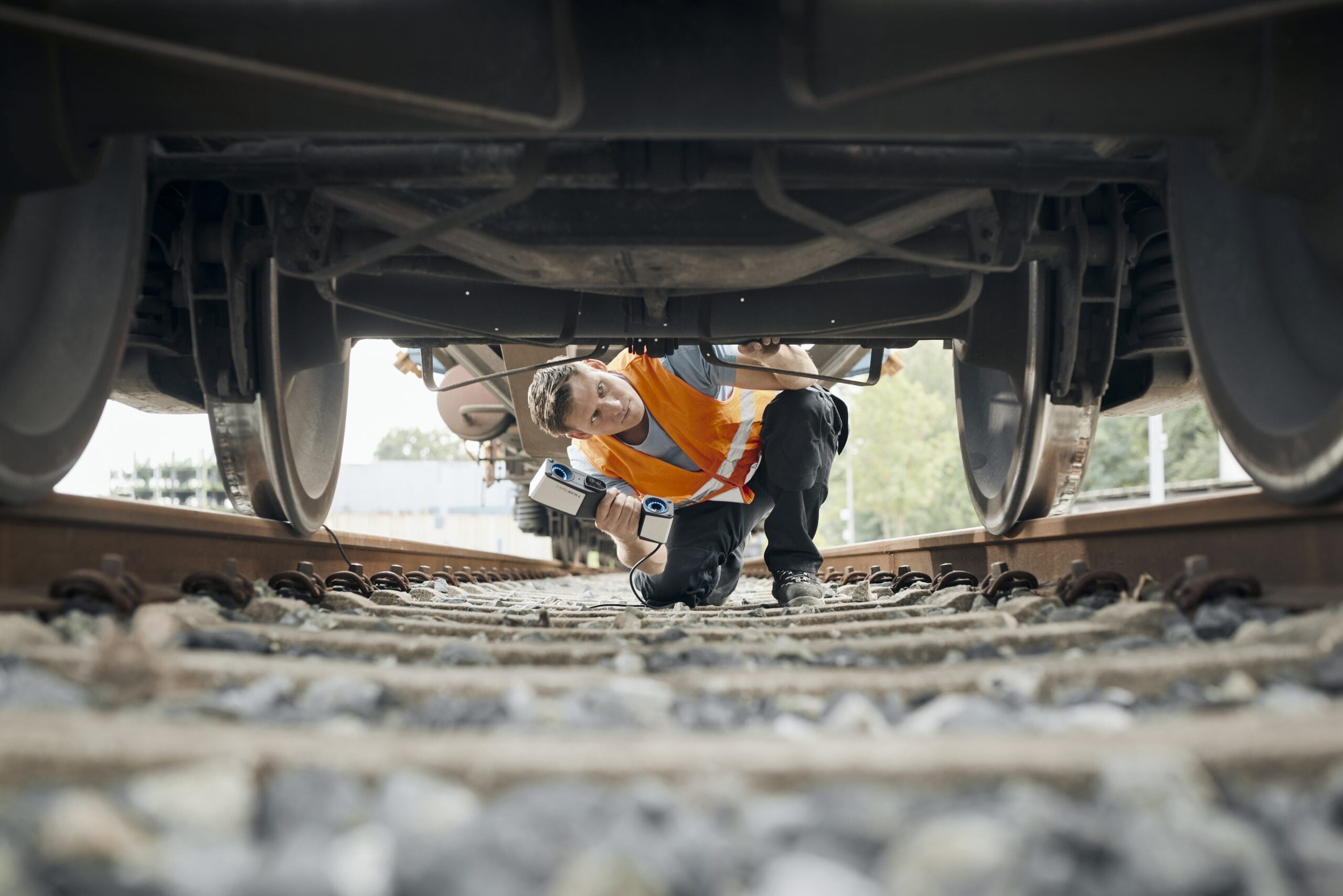 Engineer using the ZEISS T-SCAN hawk 2 to scan a train undercarriage on site