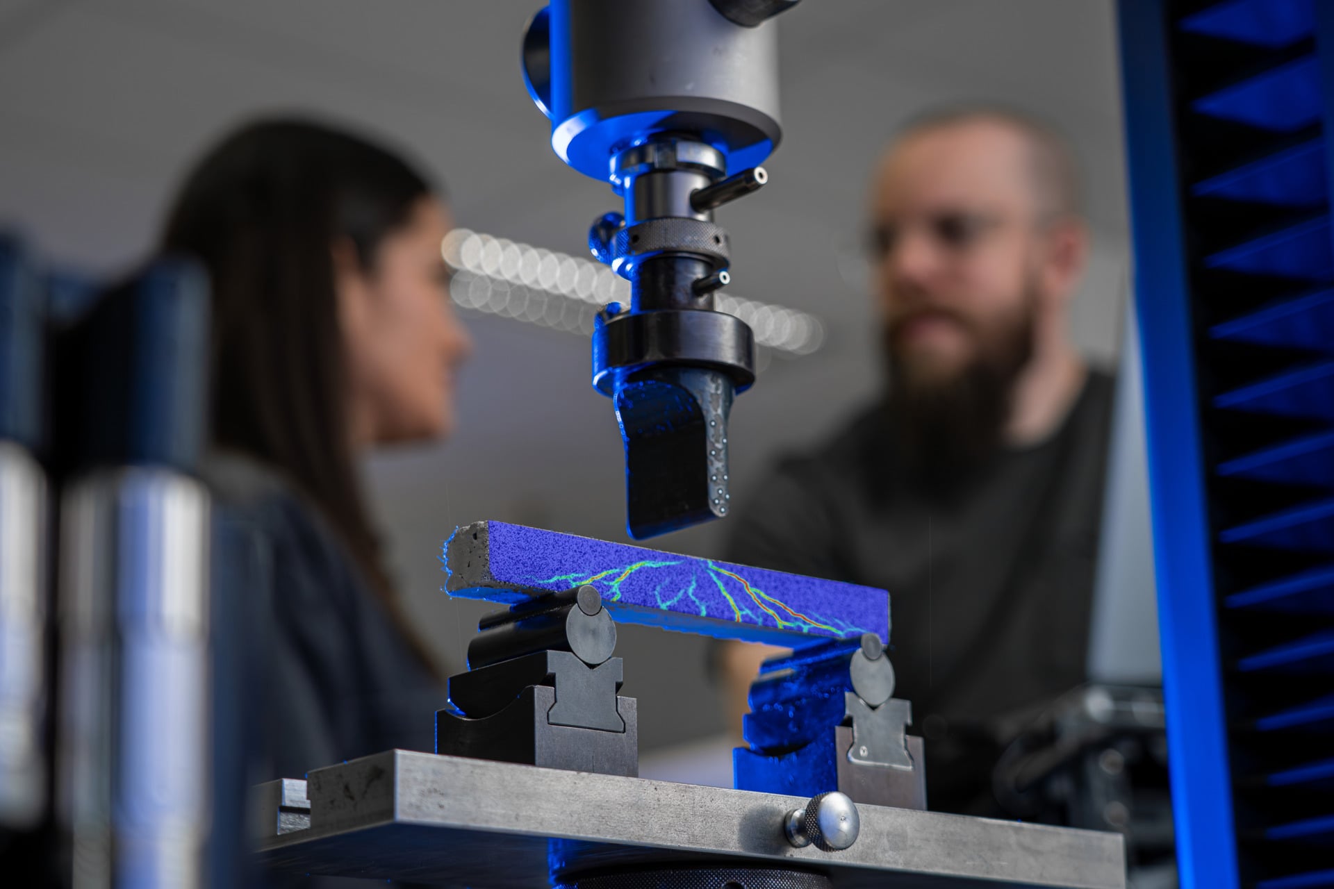 Bending-test specimen on two supports with a colour-coded optical measurement result